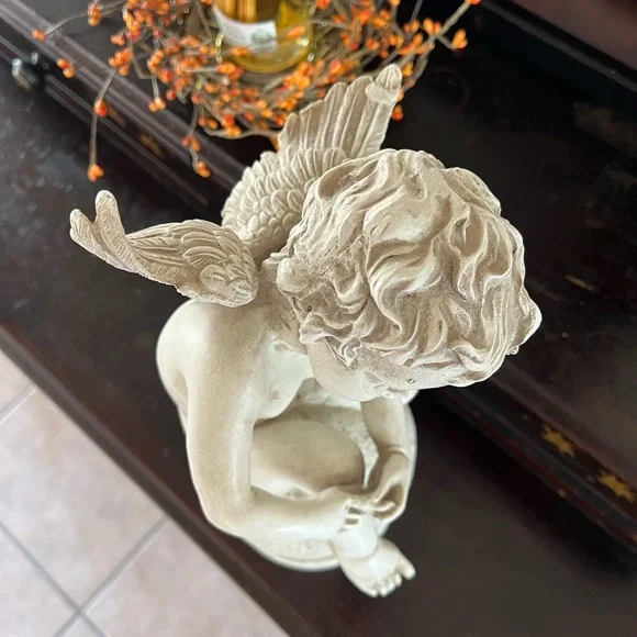 Resin angel statue on a ball 14 1/2 tall 8” wide cream colored